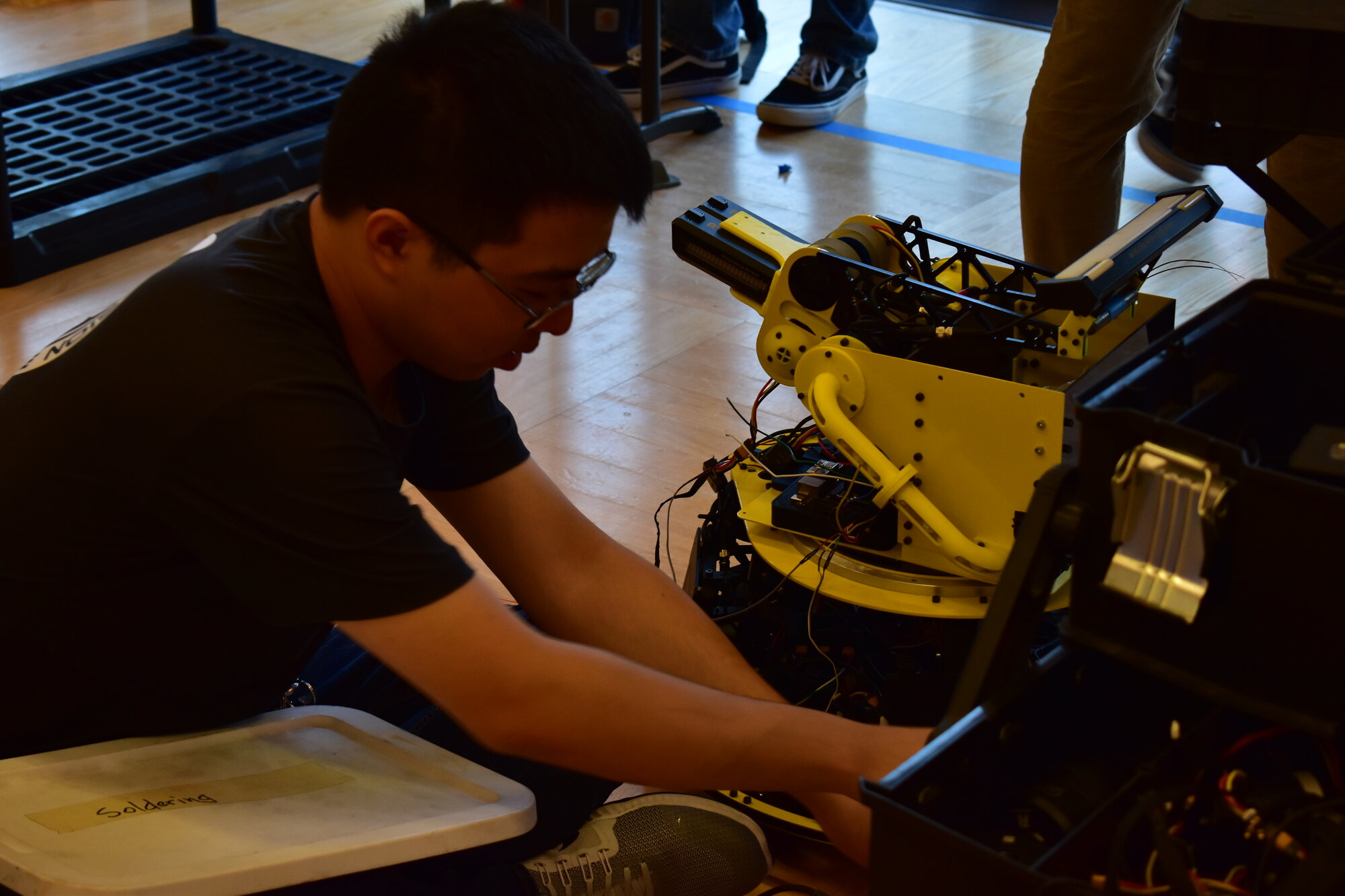 A Triton Robotics member assembling a yellow robot